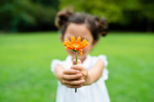 花をプレゼントしてくれるこの子供のように、困ったことは実はギフトかもしれない
